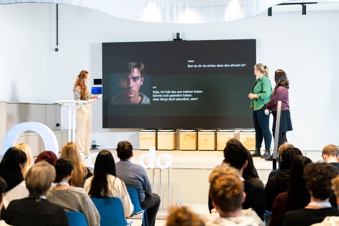 Moderation und Expertinnen auf der Bühne im Gespräch mit KI